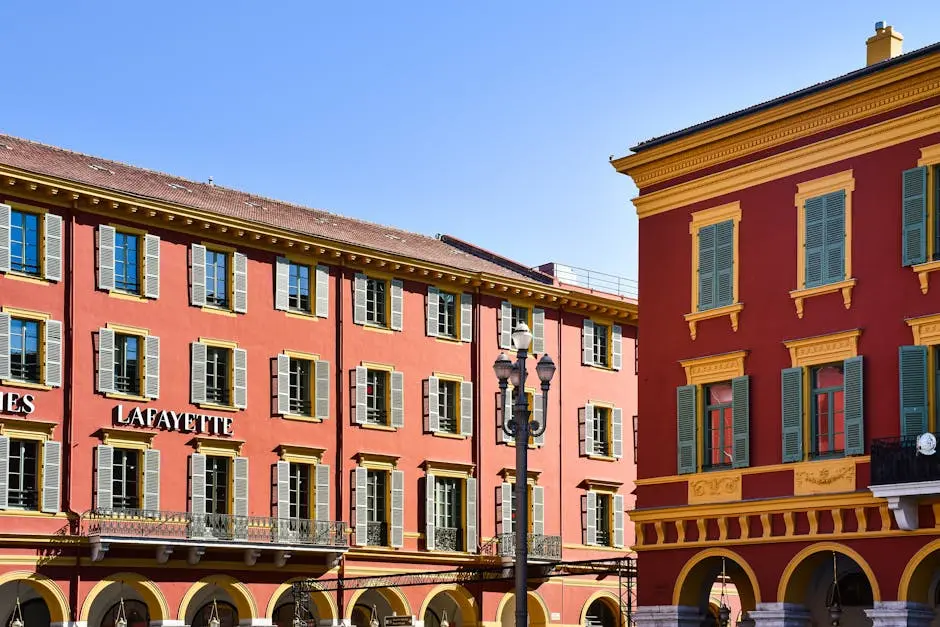 Vibrant red buildings with shutters in Nice city center, showcasing unique French architecture.