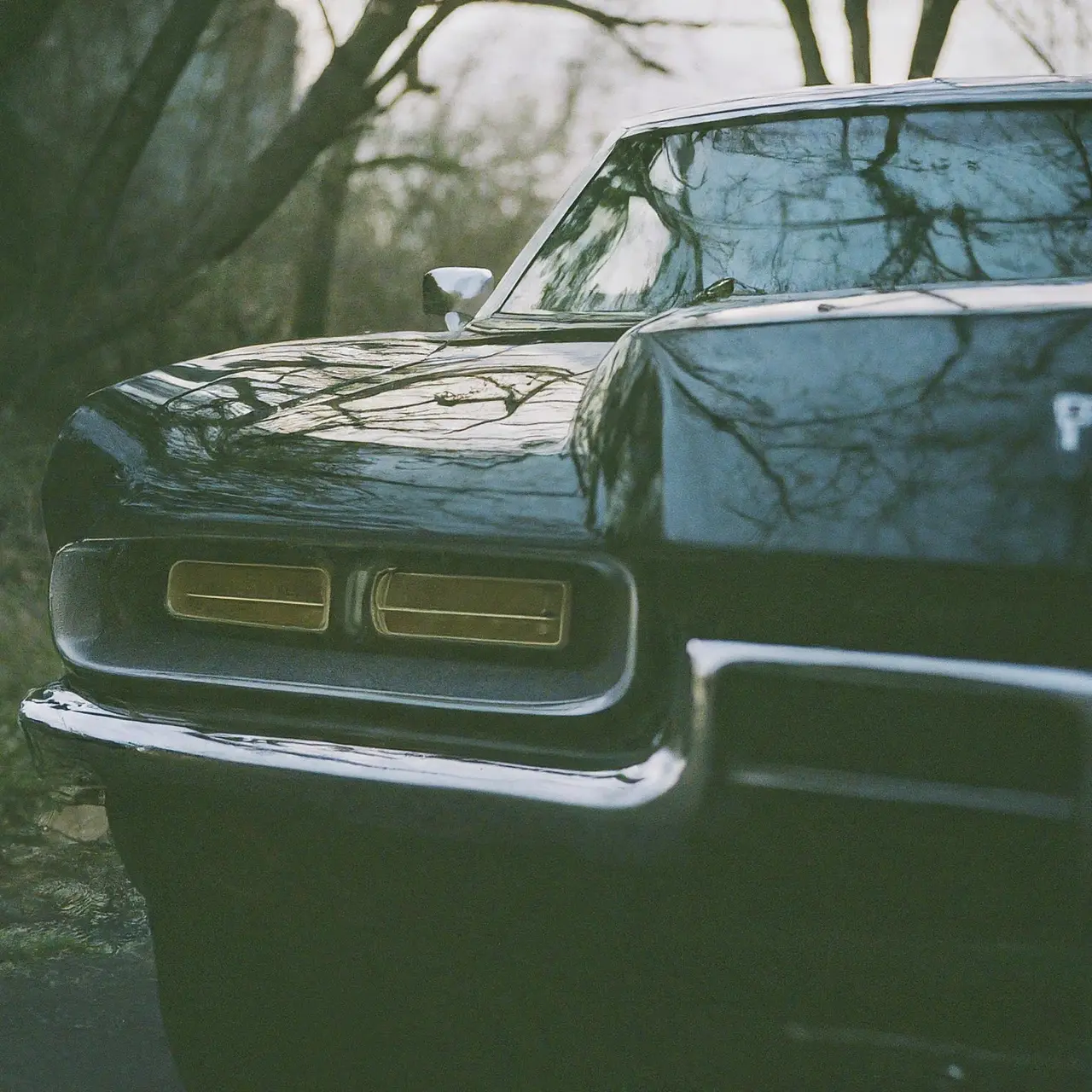 A shiny car parked outdoors with a perfect reflection. 35mm stock photo