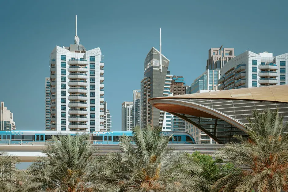 A sleek metro train passes through the modern skyline of Dubai with high-rise buildings and palm trees.