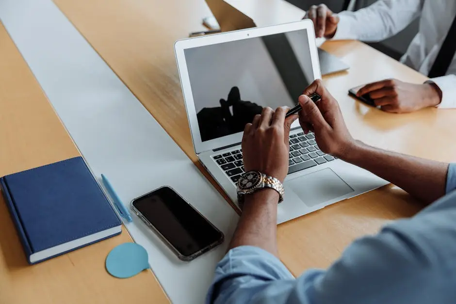 Close-up of a business meeting with laptops and smartphones, focusing on teamwork and digital collaboration.