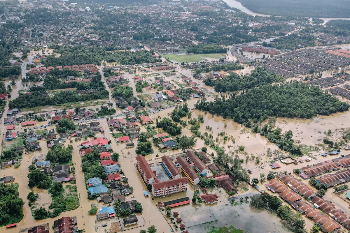 Aerial view of flooded small town with many residential houses and lush green trees