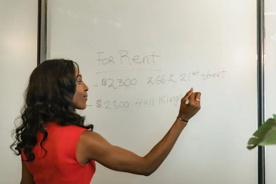 Professional woman writing real estate prices on a whiteboard for rental properties.