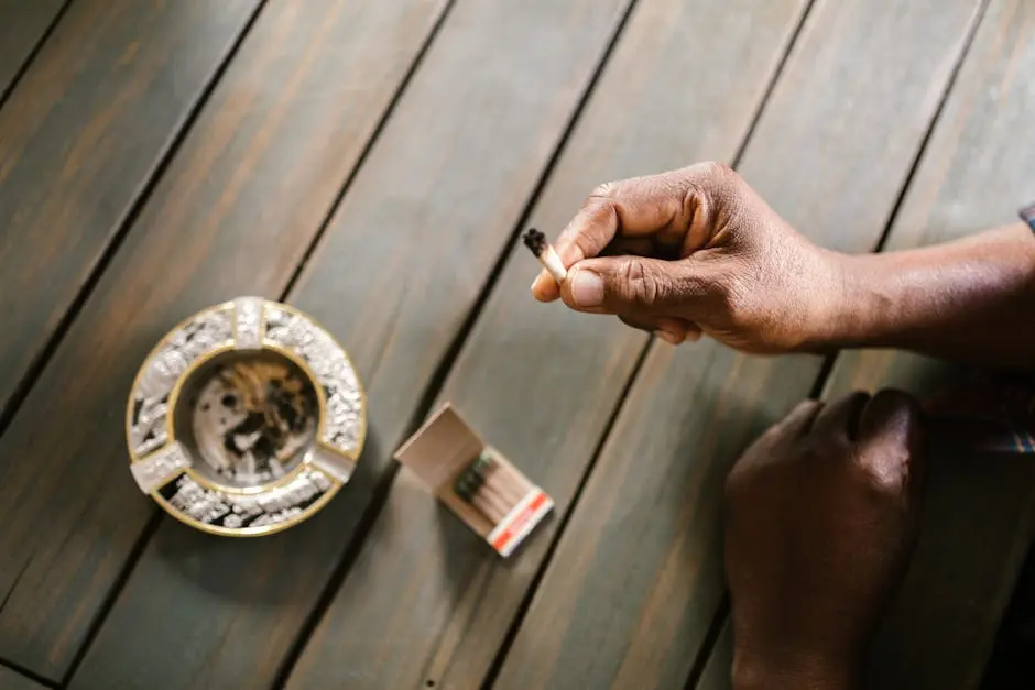 A Person Holding a Joint Near the Ashtray