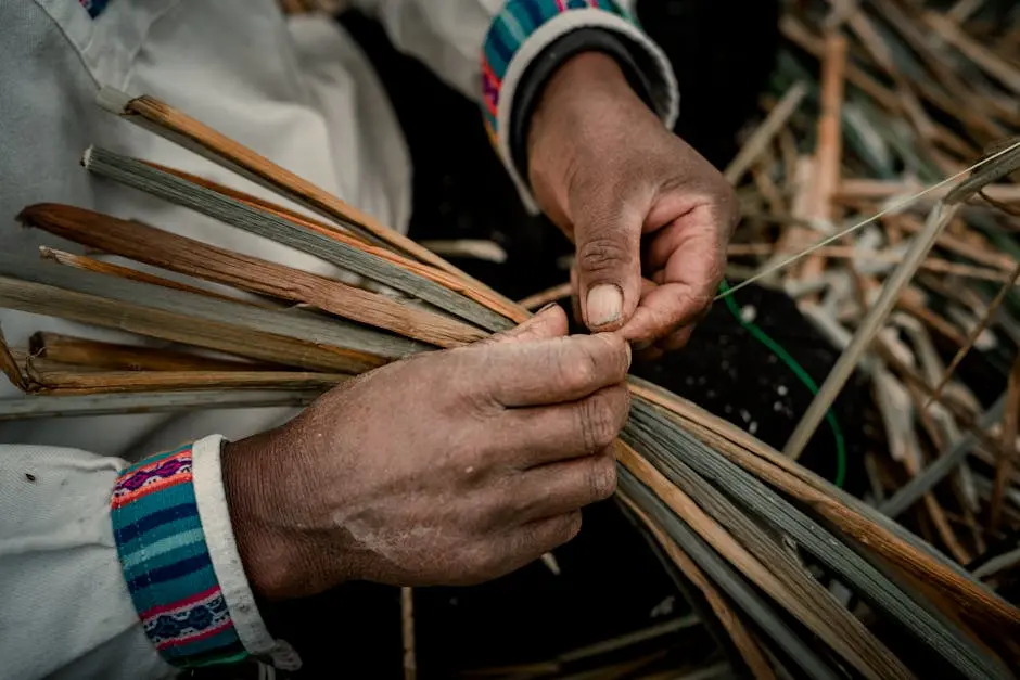 Hands of a Person Weaving Blades of Grass