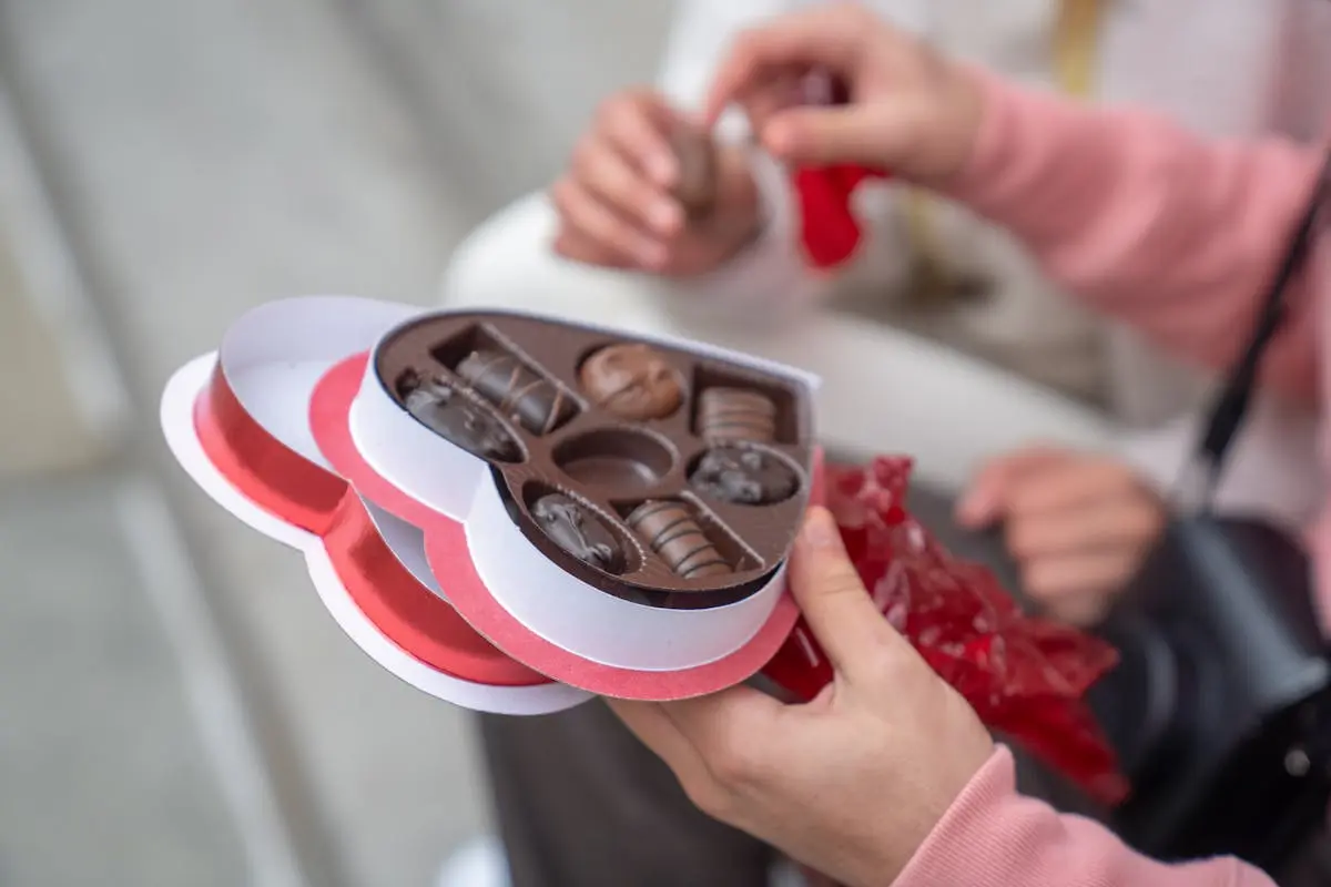 Anonymous guy giving sweet candies to girlfriend on street