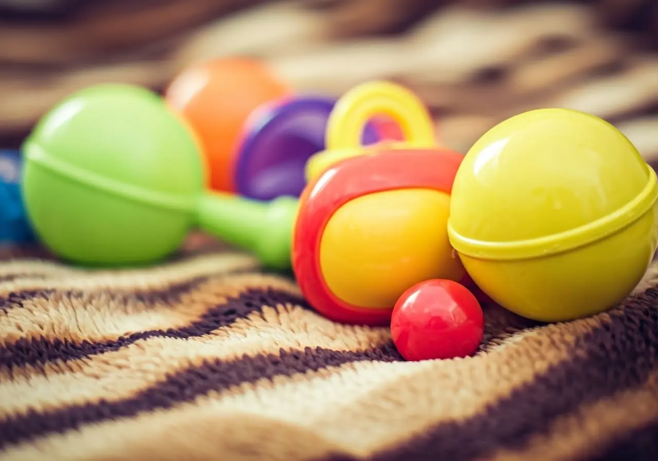 Colorful toys scattered across a soft, cozy baby blanket. 35mm stock photo