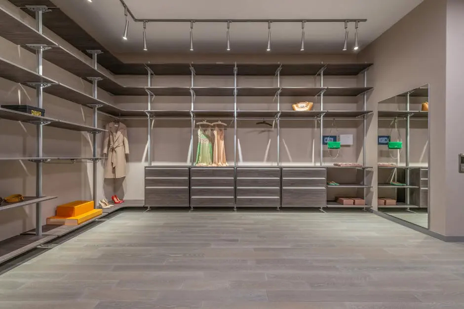 Interior of modern walk in closet with stylish wear and big window with abundance of empty shelves and cupboards in modern apartment