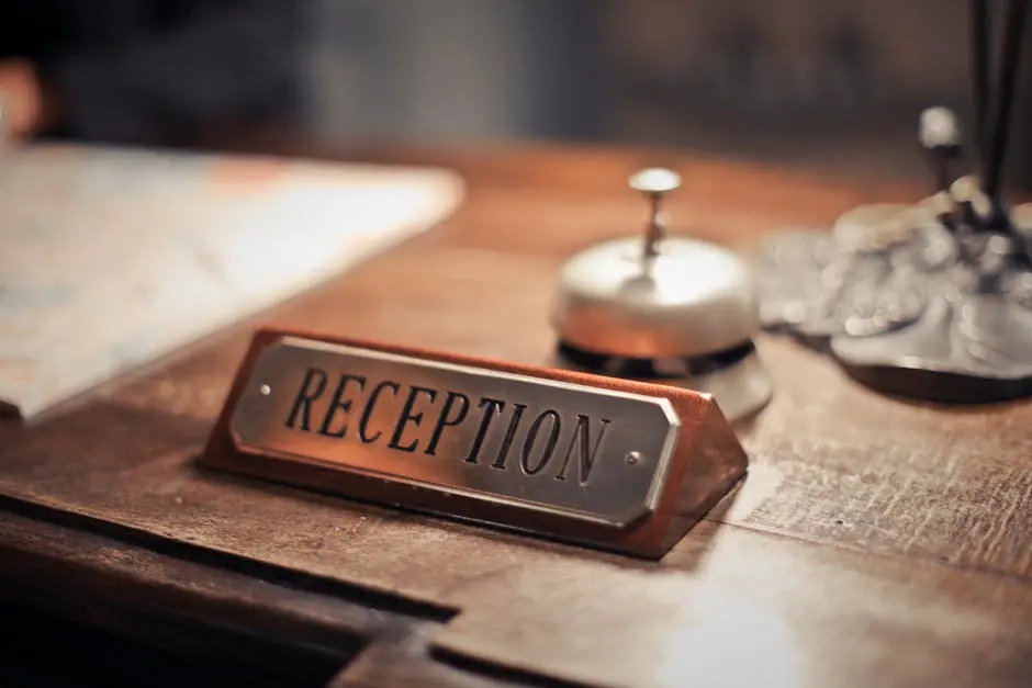 Close-up of a hotel reception desk showcasing a service bell and signage, emphasizing hospitality.