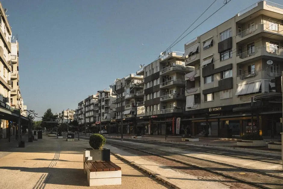 Contemporary street scene with tram lines and modern apartment buildings in the afternoon light.