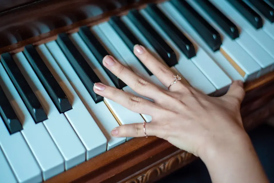 A hand with rings gracefully plays on piano keys. Captures musical elegance and craftsmanship.