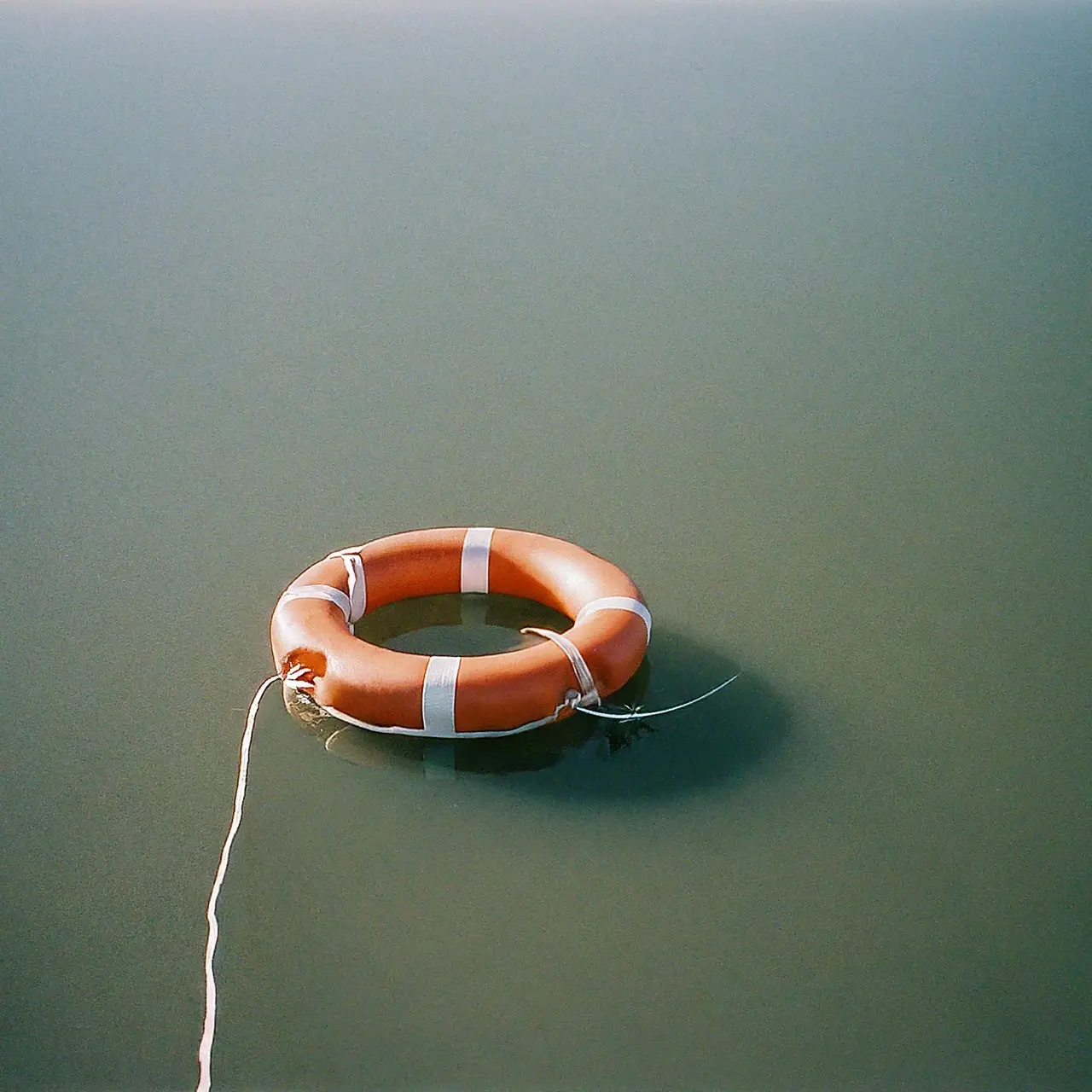 A lifebuoy floating on calm water. 35mm stock photo