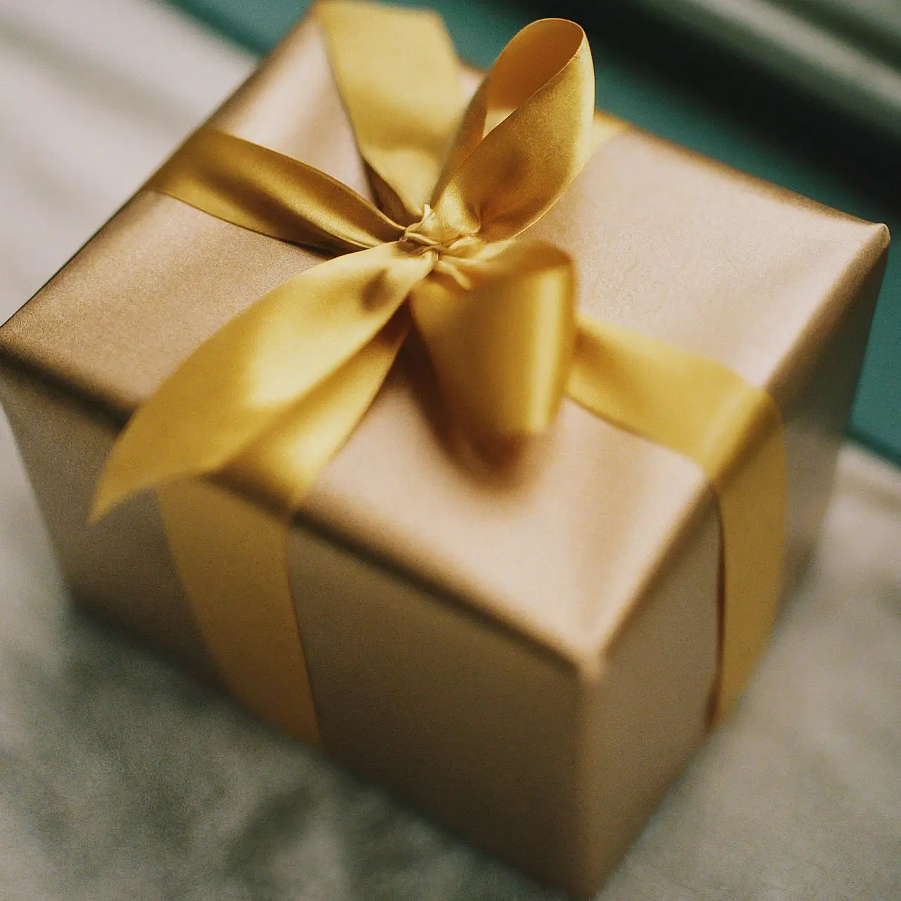 A beautifully wrapped gift box with a gold ribbon. 35mm stock photo