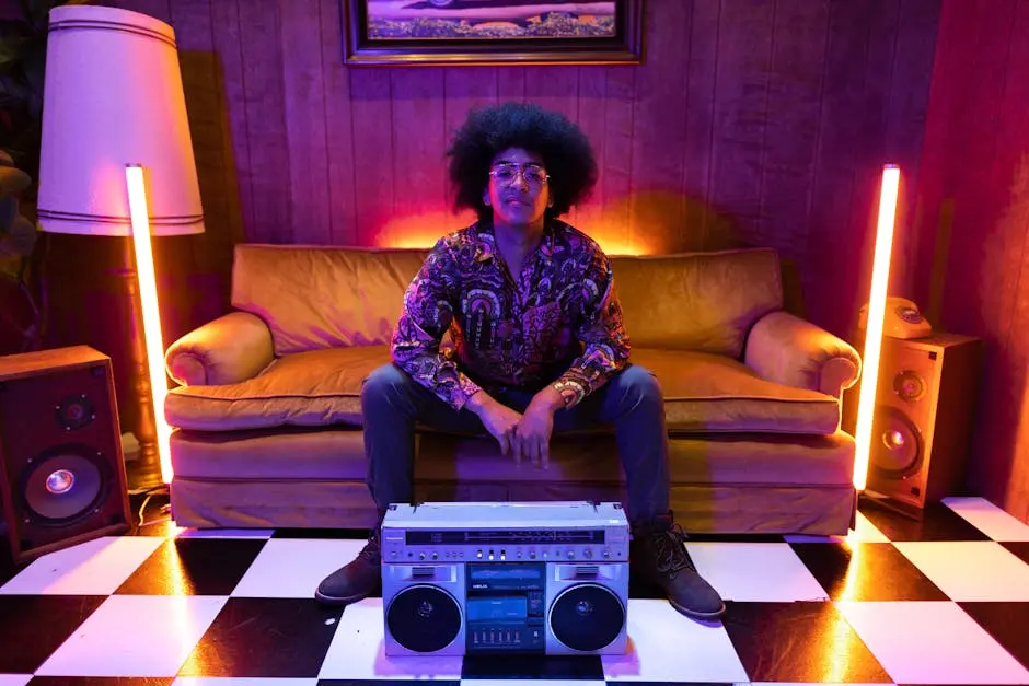 Stylish retro portrait of a man with afro hair, eyeglasses and boombox in colorful neon lit room.