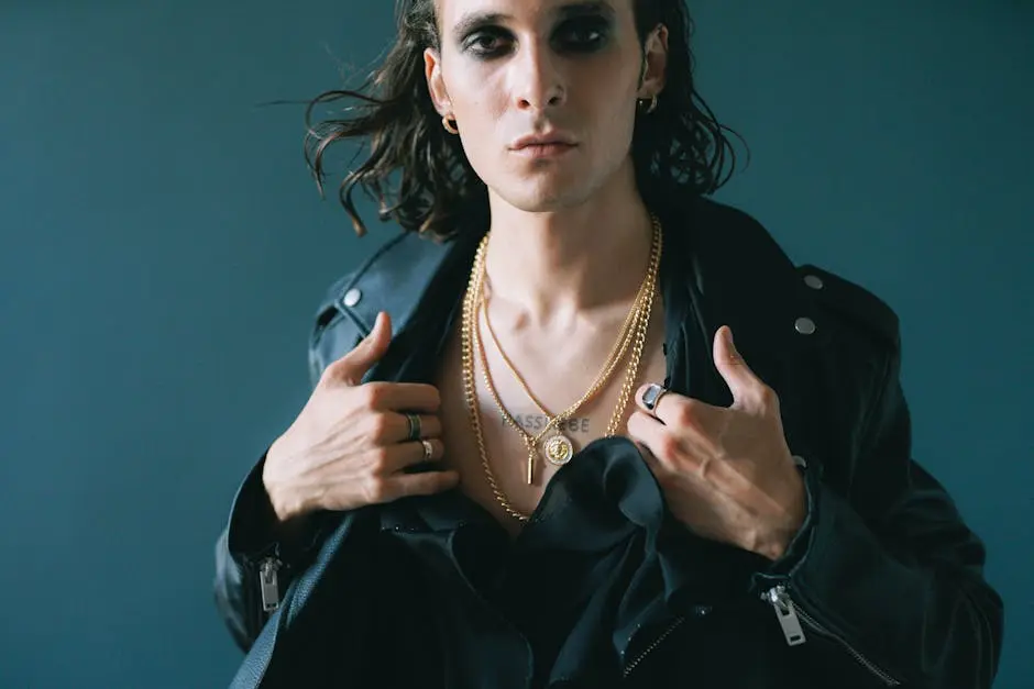 Confident man in a leather jacket showcasing necklaces and rings.