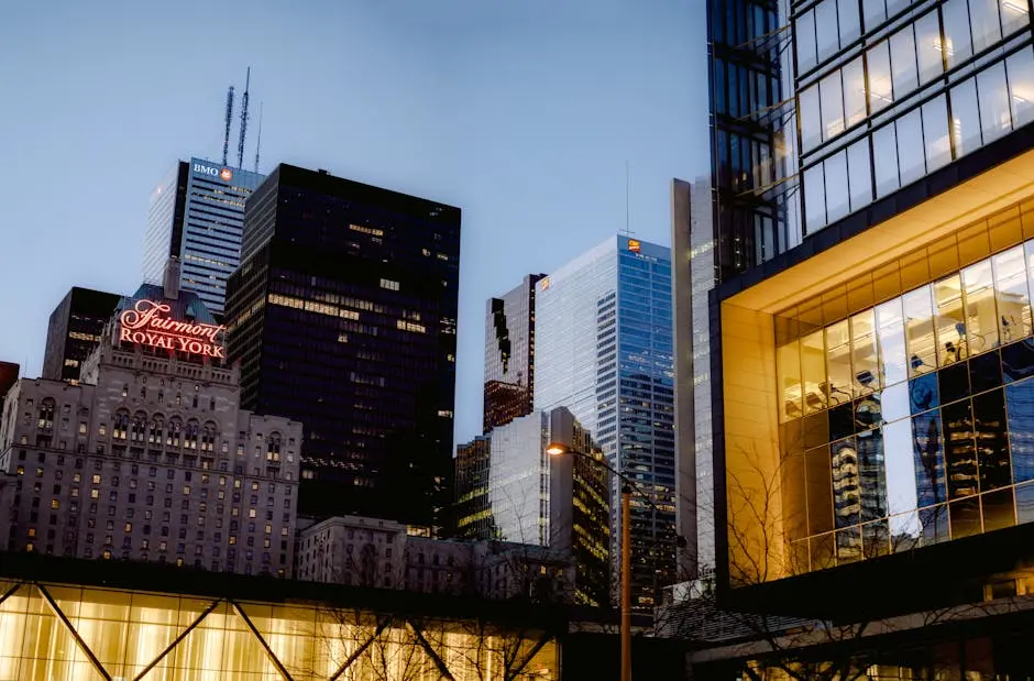 Famous hotel and multistory skyscrapers with glass walls located on street of modern district of Toronto city in evening time