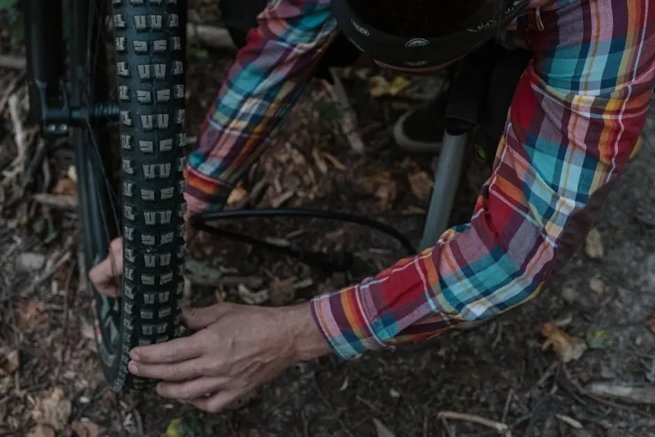 Man adjusting a bicycle tire outdoors, focusing on maintenance work.