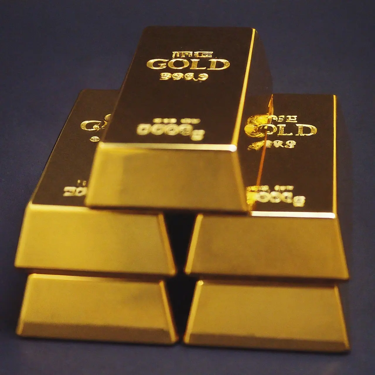 Close-up of gold bullion bars stacked on a black surface. 35mm stock photo