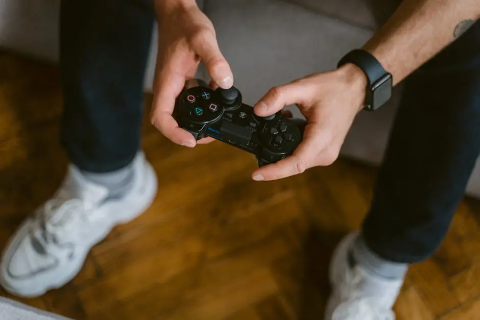 A person holding a gaming controller indoors, wearing casual attire with a smartwatch.