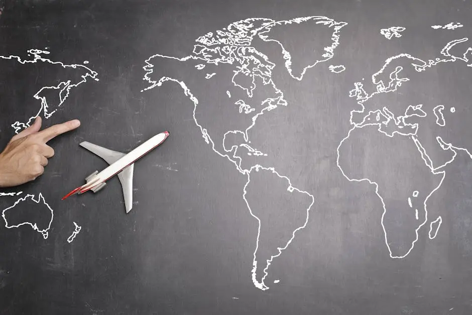 Top view of miniature airplane placed on over gray world map with crop hand of anonymous person indicating direction representing travel concept