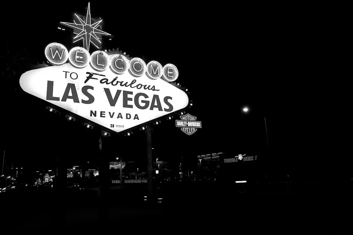 Black and white photo of the famous Las Vegas sign illuminated at night.