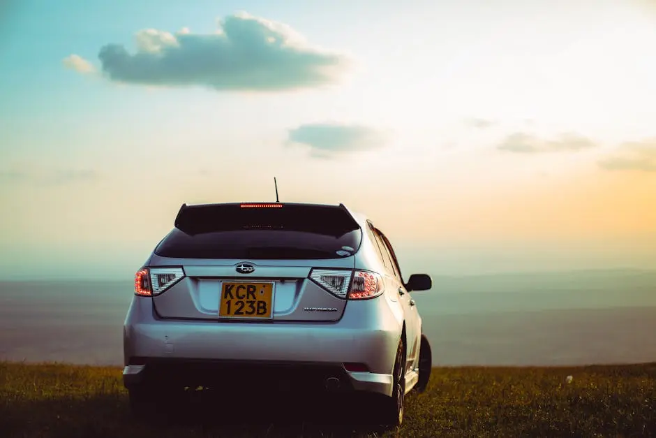 Silver SUV parked on Ngong hills overlooking Kenyan landscape during sunset.