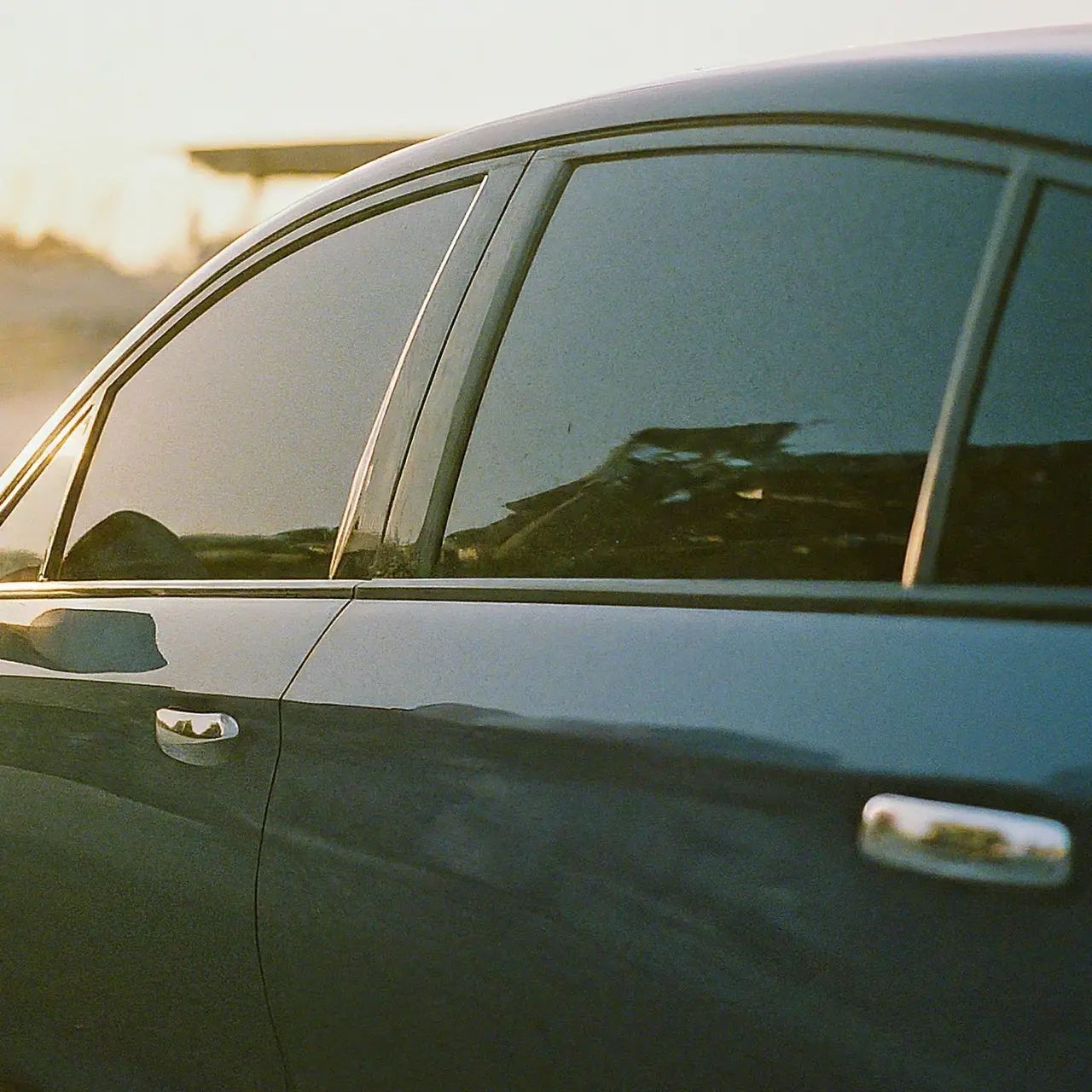 A sleek car with ceramic window tint under the sunshine. 35mm stock photo