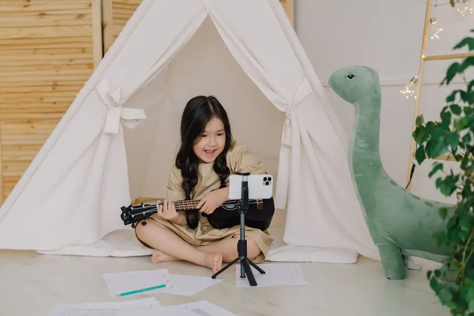 A young girl plays a ukulele indoors with a smartphone on tripod in a cozy teepee tent setup.