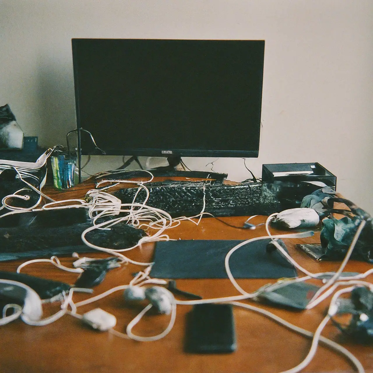 A cluttered desk with various tech devices and tangled cables. 35mm stock photo