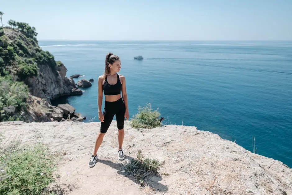 Woman in Activewear Standing on the Cliff