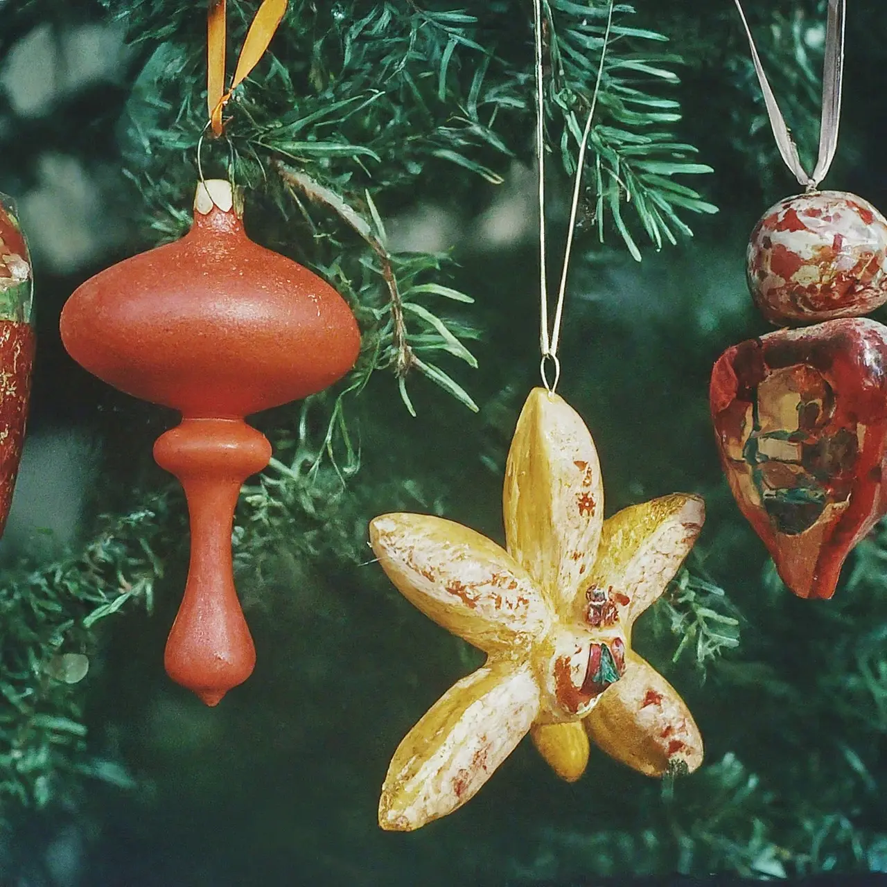 A variety of colorful, unique Christmas ornaments hanging on a tree. 35mm stock photo