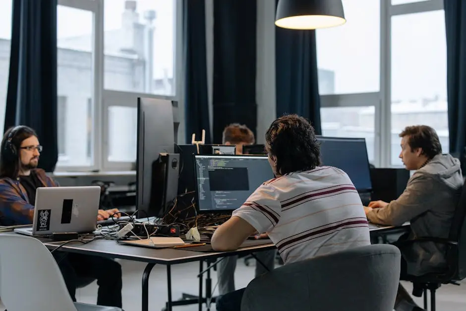 Team of developers working together on computers in a modern tech office.