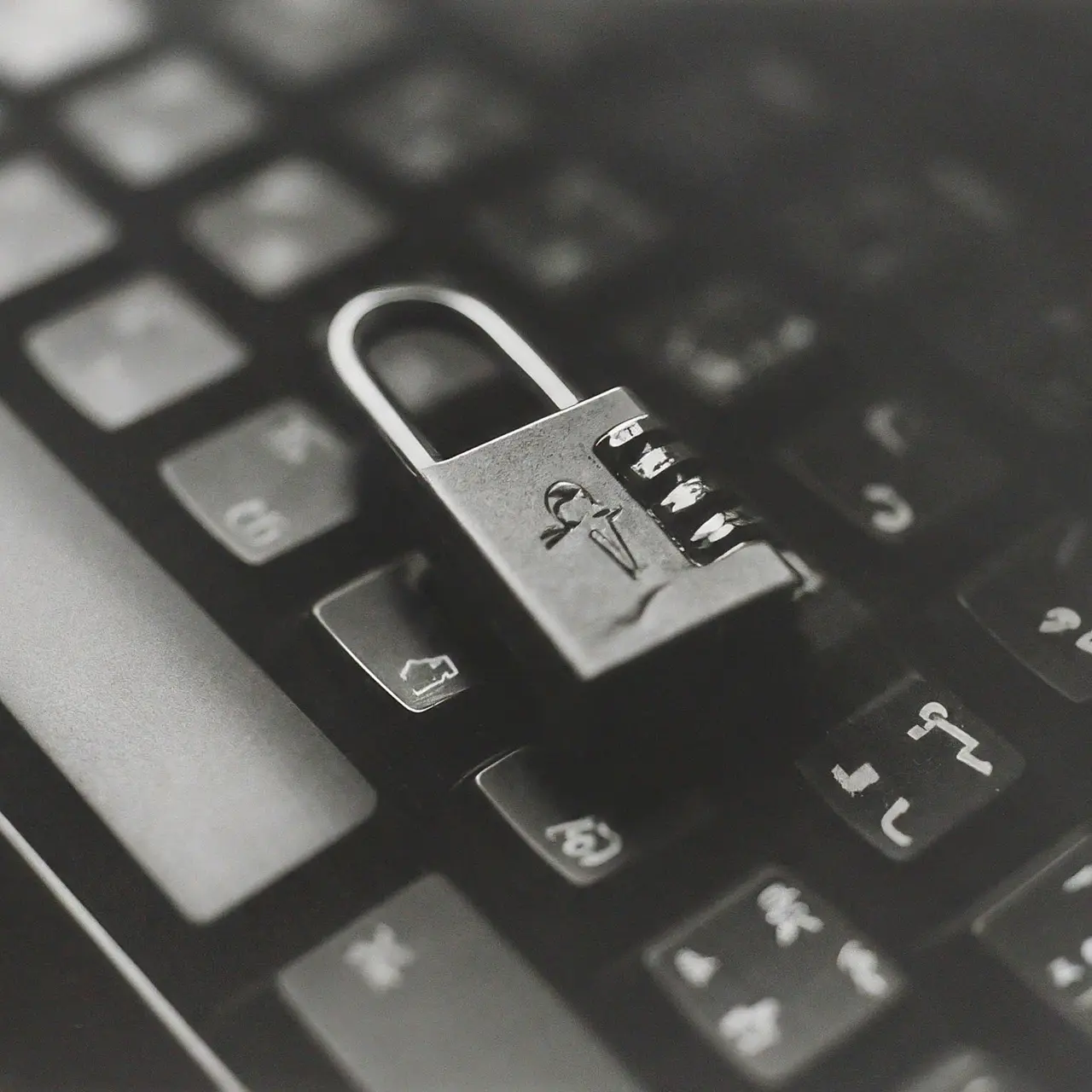 A locked padlock on a computer keyboard. 35mm stock photo