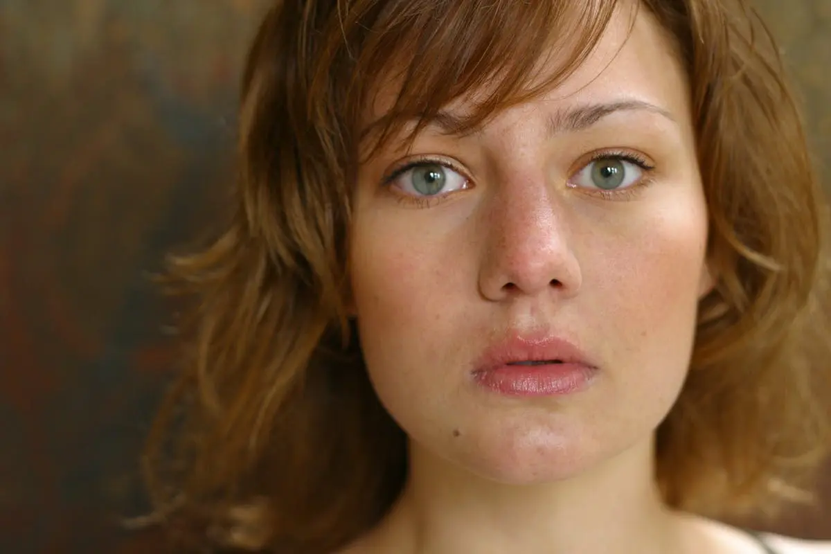 A close-up portrait capturing a young woman’s natural beauty with a serious expression.