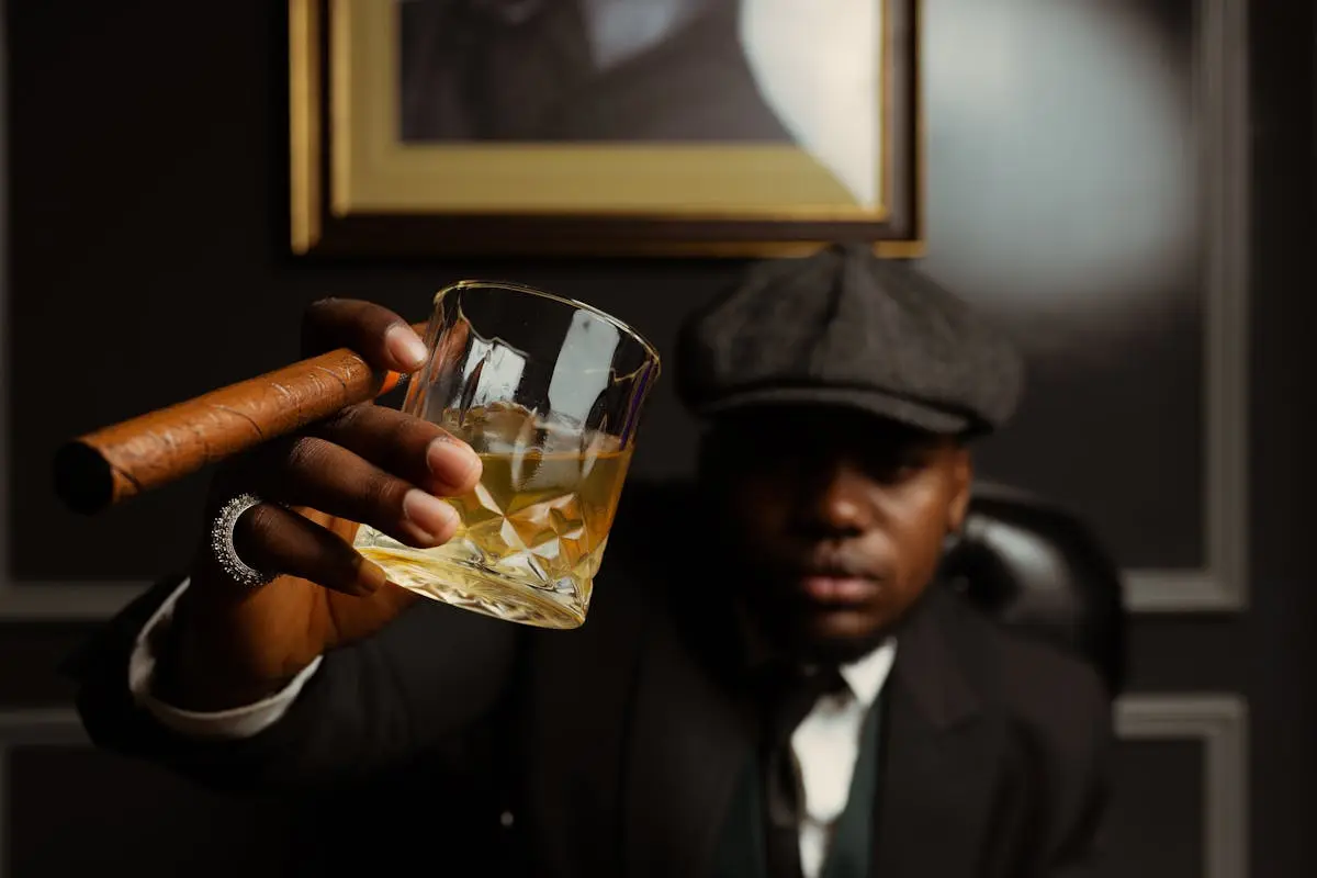 Man in a Peaked Cap Drinking Whisky and Smoking a Cigar