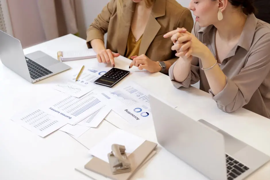 Two professionals collaborating on financial documents in a modern office setting.