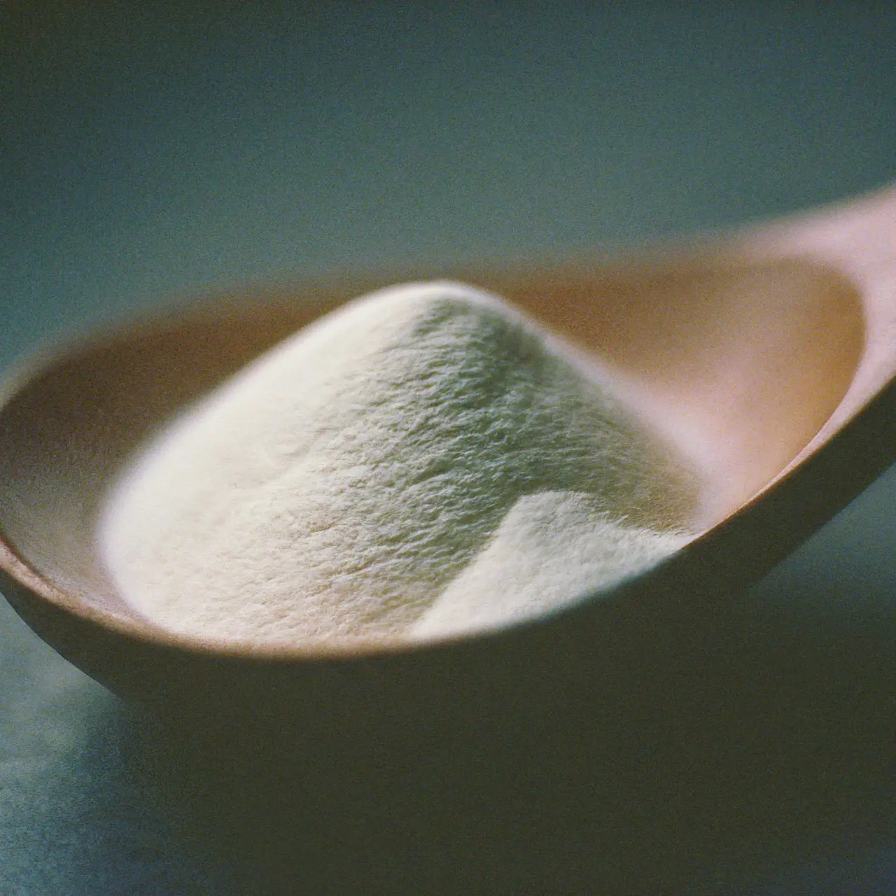 A close-up of powdered collagen in a wooden spoon. 35mm stock photo