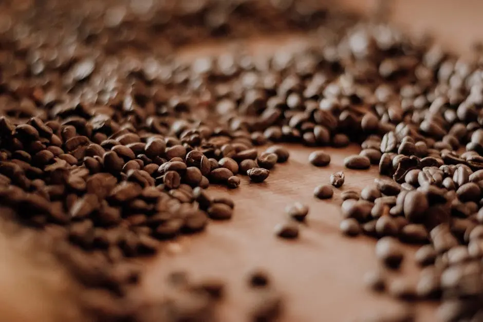 Close-up of roasted coffee beans scattered on a table, highlighting texture and aroma.