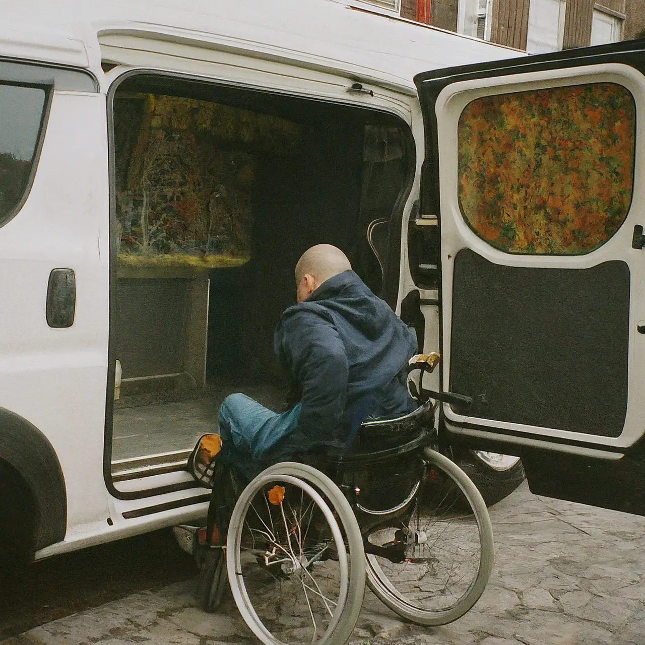 A wheelchair user boarding a specially equipped van. 35mm stock photo