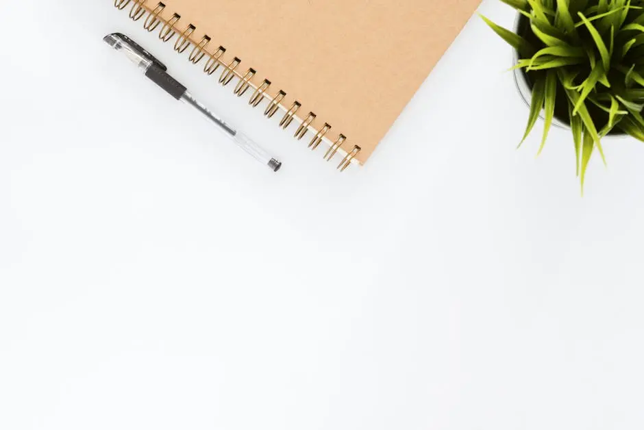 Minimalist stationery setup with a spiral notebook and pen on a clean white desk.