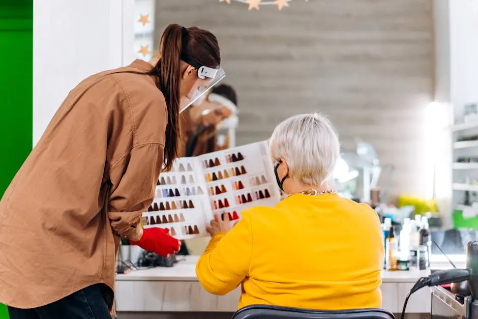 A hairstylist consults with a client using hair color samples in a salon setting.