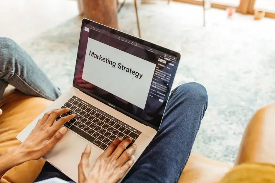 Close-up of hands using a laptop displaying a marketing strategy presentation indoors.