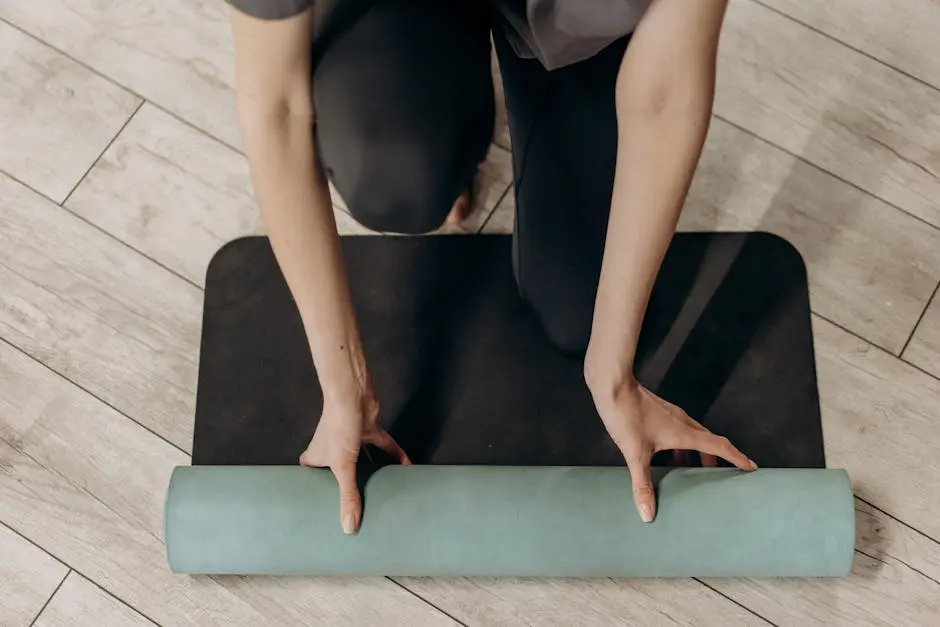 Close-up of individual rolling out a yoga mat on wooden floor, ready for a home workout.