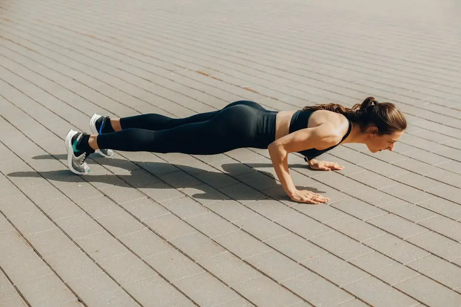 Woman performing a push-up exercise outdoors in sportswear, promoting fitness and a healthy lifestyle.