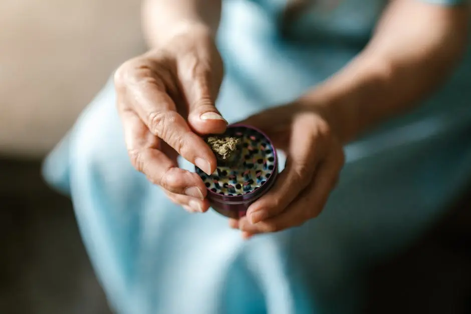 A close-up image showing hands using a weed grinder with cannabis.