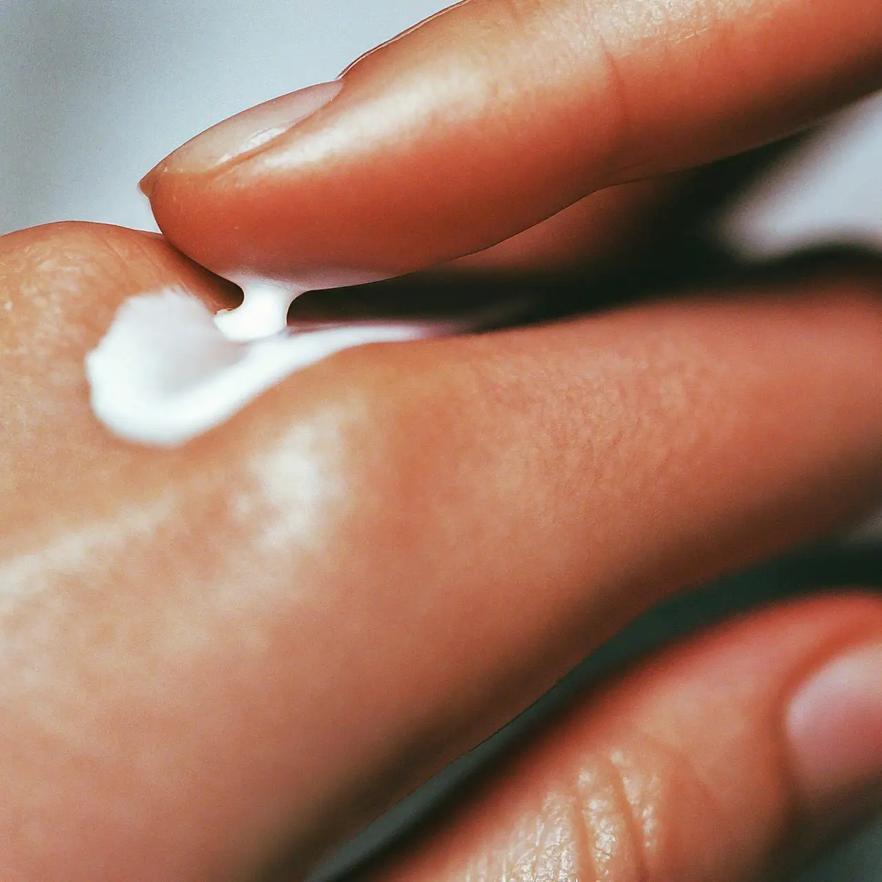 Close-up of lotion being applied on human skin. 35mm stock photo