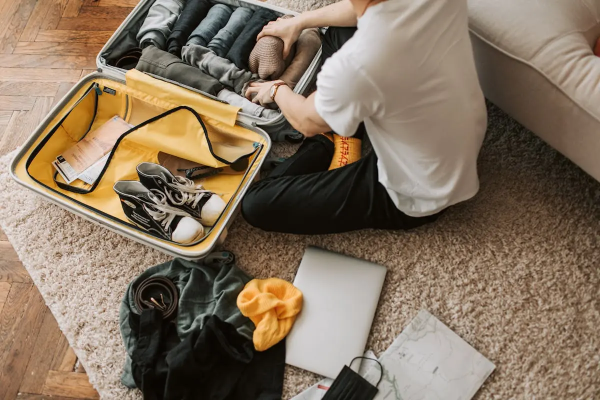 A Man Packing Clothes in His Luggage demonstrating packing techniques for the lightest backpack