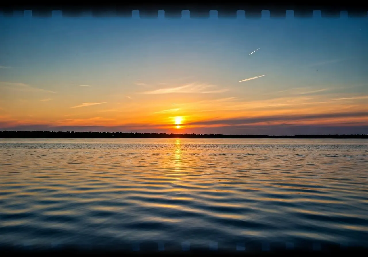 A serene sunset over a peaceful river. 35mm stock photo