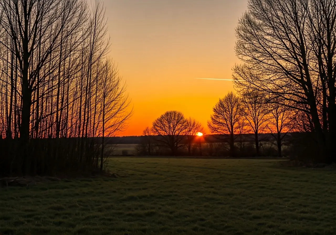 A serene sunset casting warm light over a peaceful landscape. 35mm stock photo