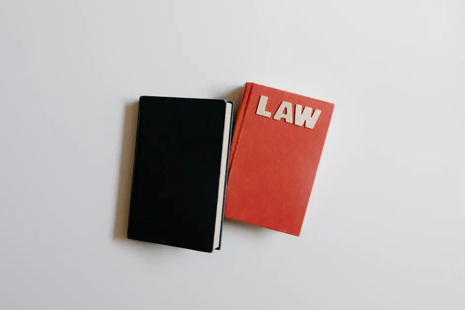 Top view of a law book and black notebook on a white surface, perfect for educational themes.