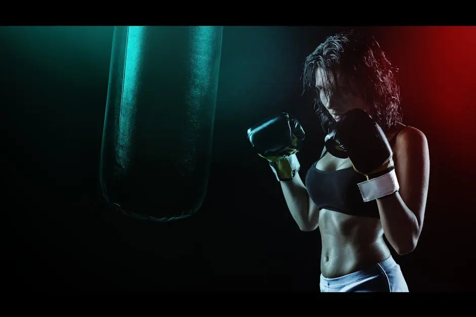 Woman in Boxing Gloves With Sports Bra Posing Boxing Style in Front of Punching Bag